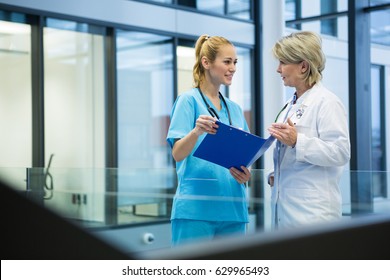 Female doctor and nurse discussing over a medical report in hospital