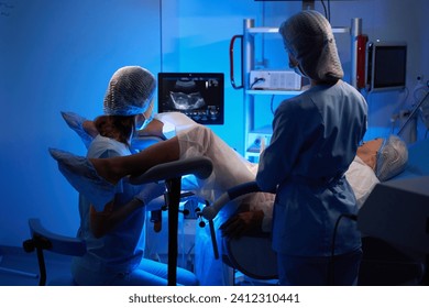 Female doctor and nurse doing embryo transfer for woman patient