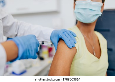 Weibliche Ärztin oder Krankenschwester, die einem Patienten einen Schuss oder Impfstoff auf die Schulter gibt. Impfung und Vorbeugung gegen Grippe oder Viruspandemie. 