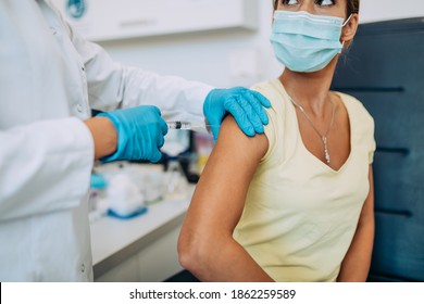 Female doctor or nurse giving shot or vaccine to a patient's shoulder. Vaccination and prevention against flu or virus pandemic.  - Shutterstock ID 1862259589
