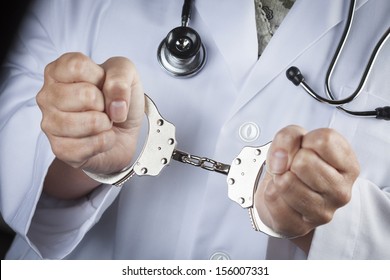 Female Doctor or Nurse In Handcuffs Wearing Lab Coat and Stethoscope.