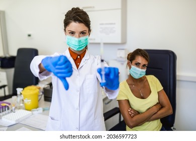 Female Doctor Or Nurse Holding Vaccine And Showing Thumbs Down.