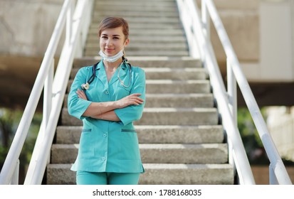 Female Doctor Or Nurse In A Protective Face Mask Walking Up The Stairs