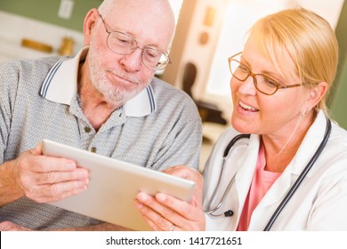 Female Doctor Or Nurse Showing Senior Man Touch Pad Computer At Home.