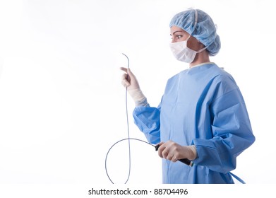 Female Doctor Or Nurse Wearing A Blue Sterile Suit Or Gown Holding An Ablation Catheter For A Cardiac Procedure