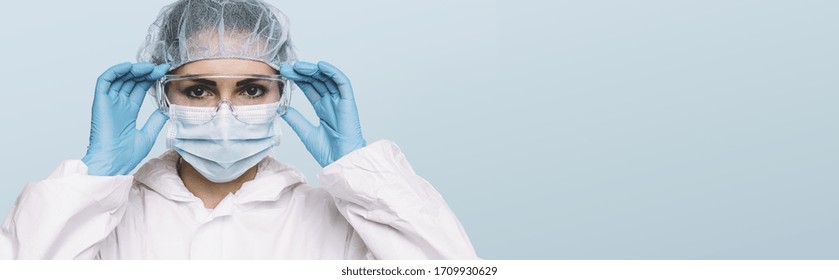 Médica o enfermera que usa guantes protectores de látex y máscara protectora y gafas médicas en la cara. Protección para Coronavirus COVID-19, con espacio de copia para tu texto individual.