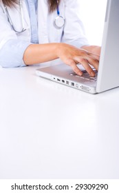 Female Doctor On Computer At Desk Isolated On White