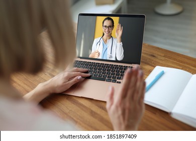 Female Doctor On Laptop Screen Waving Hand To Sick Patient. Development Of Telemedicine Online Consultation During A Pandemic Concept