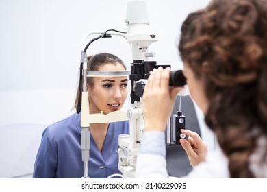 Female Doctor Ophthalmologist Is Checking The Eye Vision Of Attractive Young Woman In Modern Clinic. Doctor And Patient In Ophthalmology Clinic