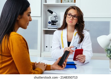 Female Doctor With Patient Using Mobile Phones In Hospital Healthcare Industry