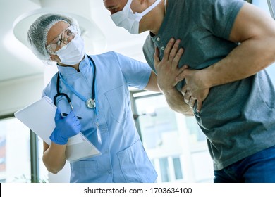 Female Doctor With A Patient Who Is Complaining Of Chest Pain During Coronavirus Epidemic. 