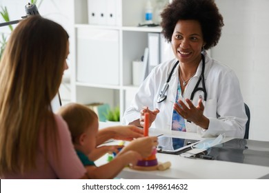 Female Doctor Pediatrician With Baby Patient And Mother. Pediatrician Doing An Infant Medical Exam. Early Child Development And Care