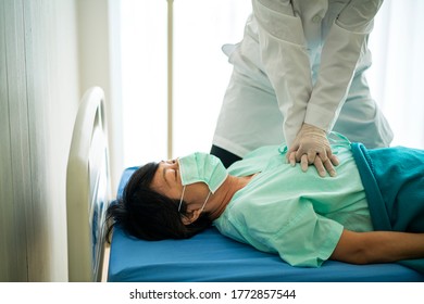 Female Doctor Performing CPR On Unconscious Coronavirus Or Covid-19 Patient In Emergency Room At Hospital