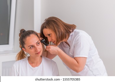 Female Doctor Performing An Otolaryngological Exam On A Cute Teen Girl.