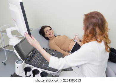 a female doctor performs ultrasound diagnostics of the intestine, abdominal cavity, right lobe, liver, bile ducts, gallbladder. Soft tissue examination using a portable sensor device.