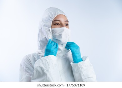 Female Doctor In PPE (personal Protective Equipment), Wearing Safety Glasses Gloves Face Mask And Take Off Hazmat Suite.