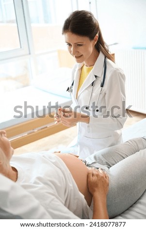 Female doctor preparing syringe to injection and looking at pregnant woman