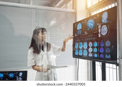 Female doctor presenting x-ray film brain human of patient on digital monitor showing MRI, CT scans brain images. Doctor Scientist checking examining viral infection on monitor - Powered by Shutterstock