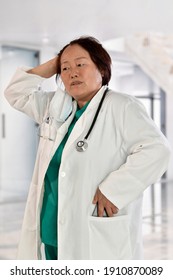Female Doctor Putting Away Her Phone While Looking Distressed