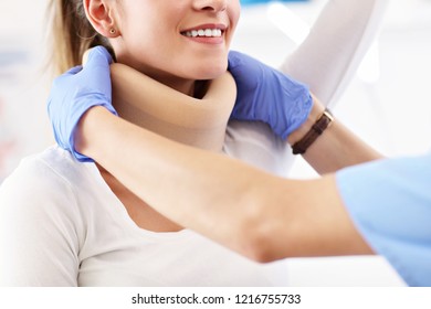 Female Doctor Putting Neck Orthopaedic Collar On Adult Injured Woman