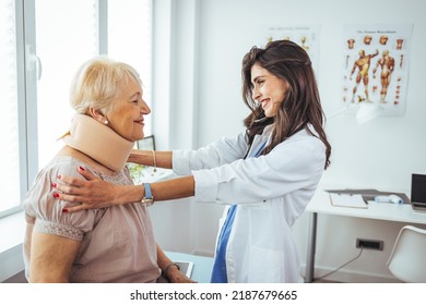 Female Doctor Putting Neck Orthopaedic Collar On Adult Injured Woman. Woman In Pain At The Doctor For A Neck Injury. Doctor Giving A Prescription To A Senior Patient With Cervical Collar