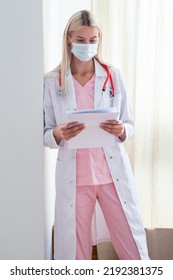 Female Doctor Reviewing Test Results. Caucasian Woman Working In Clinic.