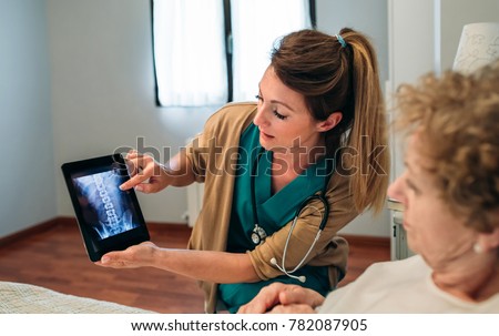 Female doctor showing an x-ray on the tablet