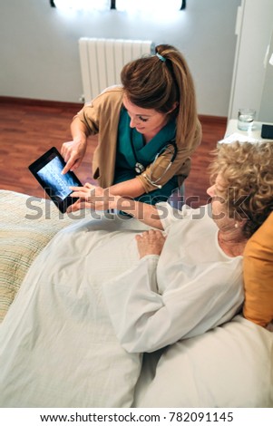 Similar – Female doctor showing results of a medical test on the tablet