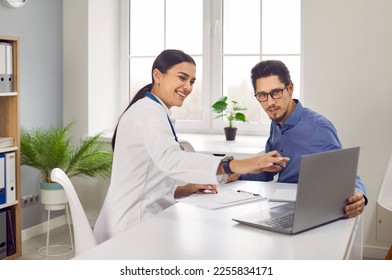 Female doctor showing test results to patient on laptop computer. General practitioner consulting male client at medical checkup visit. Medicine and healthcare concept - Shutterstock ID 2255834171