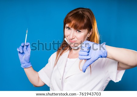 Female doctor showing thumb down holding syringe in hand