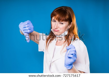 female doctor shows thumb down in medical mask