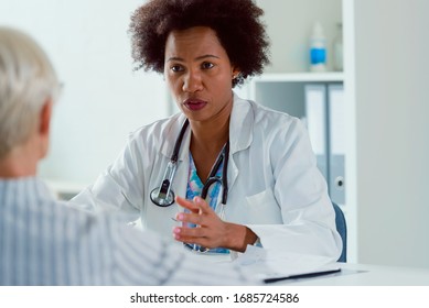 A female doctor sits at her office and examining elderly female patient