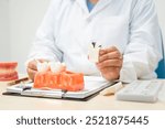  A female doctor sits at a table in a hospital, discussing dental issues like wisdom teeth, cavities, dentures,missing teeth, and cracked teeth, explaining the causes and treatment of dental caries.