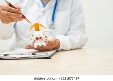 A female doctor sits at a table in a hospital, discussing spine conditions like scoliosis,lumbar disc herniation, degenerative spine disease,and spinal fractures,highlighting risks such as paralysis - Powered by Shutterstock