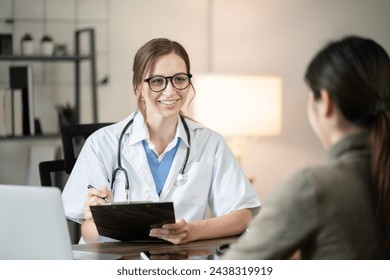 Female doctor sitting at work looking at the history of patients in the clinic or in the hospital - Powered by Shutterstock