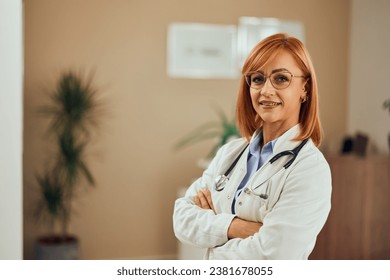 A female doctor smiling for the camera, holding hands crossed, wearing a coat and a stethoscope around her neck. - Powered by Shutterstock