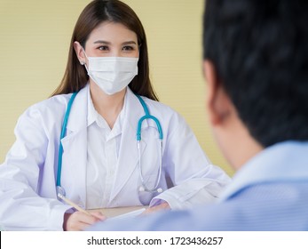 A Female Doctor Is Smiling Face Under The Surgical Mask And Looking To Male Patients, Ideas For Healthcare Concepts.