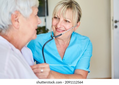 Female doctor with stethoscope examining an old woman on a home call or in a nursing home