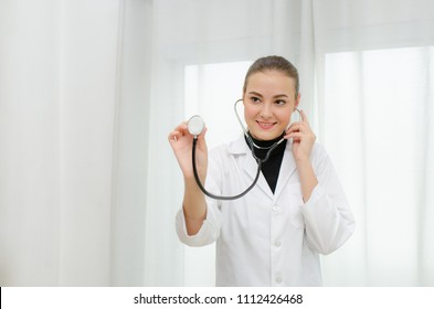 Female doctor with stethoscope in hand. She smiles sweetly to the patients who are diagnosed.