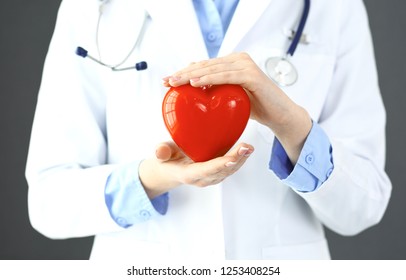 Female doctor with stethoscope holding heart in her arms. Healthcare and cardiology concept  in medicine 