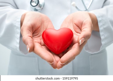 Female doctor with the stethoscope holding heart