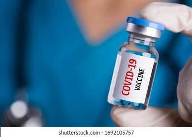Female doctor with a stethoscope on shoulder holding syringe and COVID-19 vaccine. Healthcare And Medical concept. - Shutterstock ID 1692105757