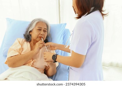 Female doctor takes care elderly female patients with friendliness drink clean refreshing water willingness make the patients feel good giving encouragement recuperate their illnesses in the hospital. - Powered by Shutterstock