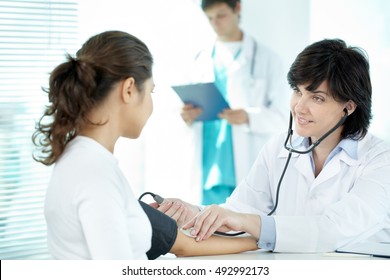 Female Doctor Taking Blood Pressure