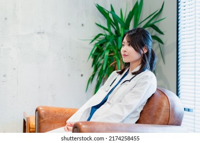 Female Doctor Taking A Break In Her White Coat