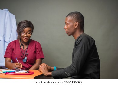 Female Doctor Taking Notes While Conducting A Check Up