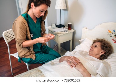 Female doctor taking temperature to senior woman at home - Powered by Shutterstock