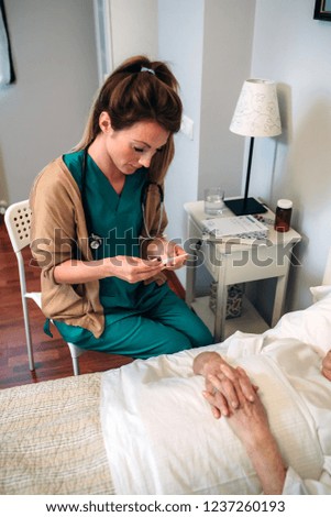 Similar – Female doctor giving medication to elderly patient