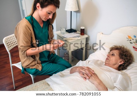 Similar – Female doctor giving medication to elderly patient