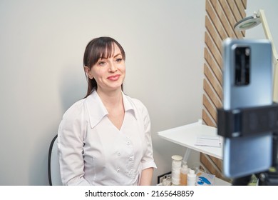 Female Doctor Talk To Patient By Phone. Telemedicine Content. Tripod Hold Camera. Blogger Therapist. Telehealth Media Record. Internet Clinic Speech. Hospital Webinar Office